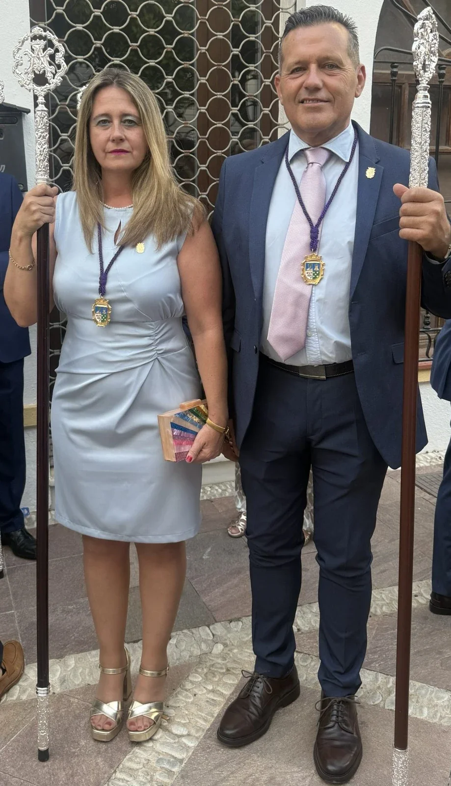 Cristina RJ Osorio y un acompañante con varas de mando en un acto
